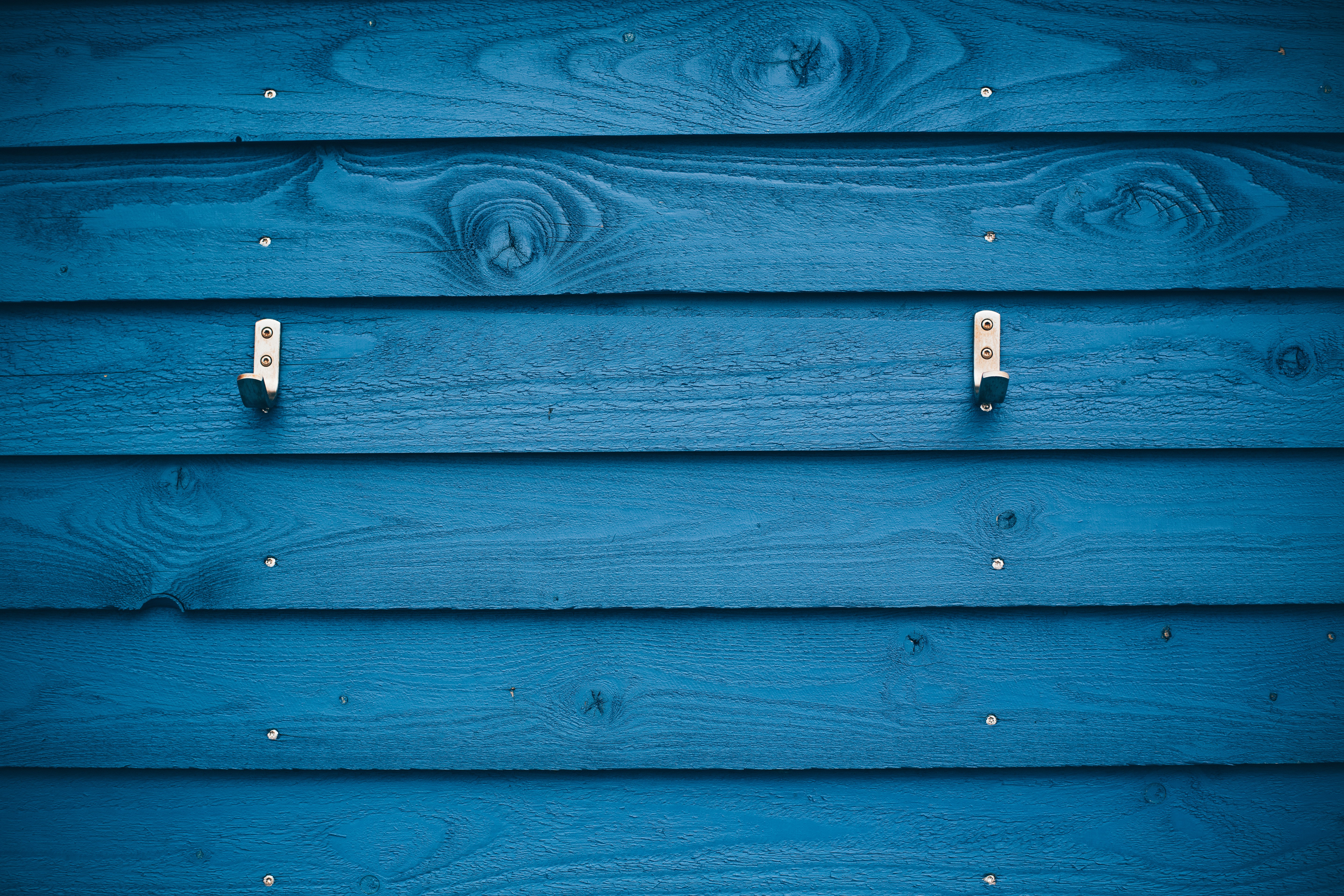 grey metal hook on blue wood plank